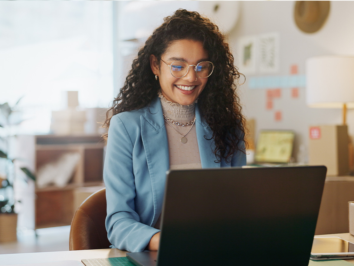 Frau mit Brille sitzt am Laptop